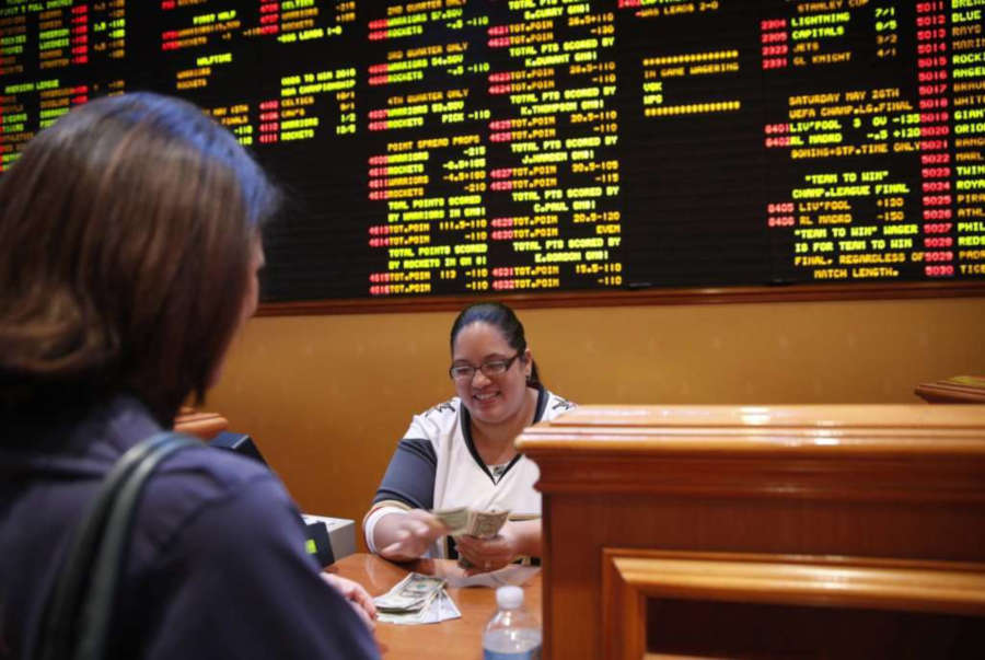 A sports betting cashier behind the counter.