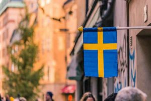 A street in Sweden with the national flag overhead.